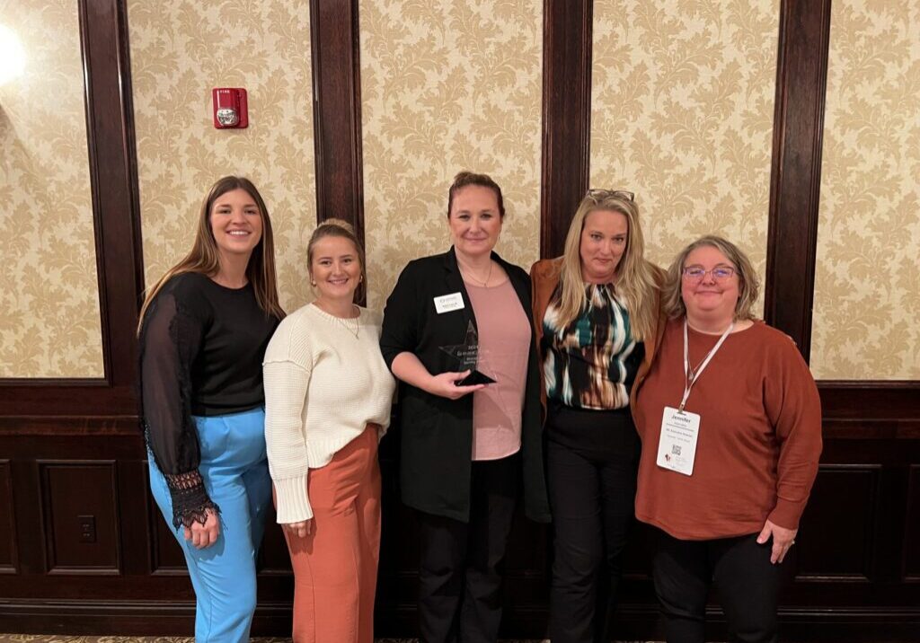 North Shore Team standing with award